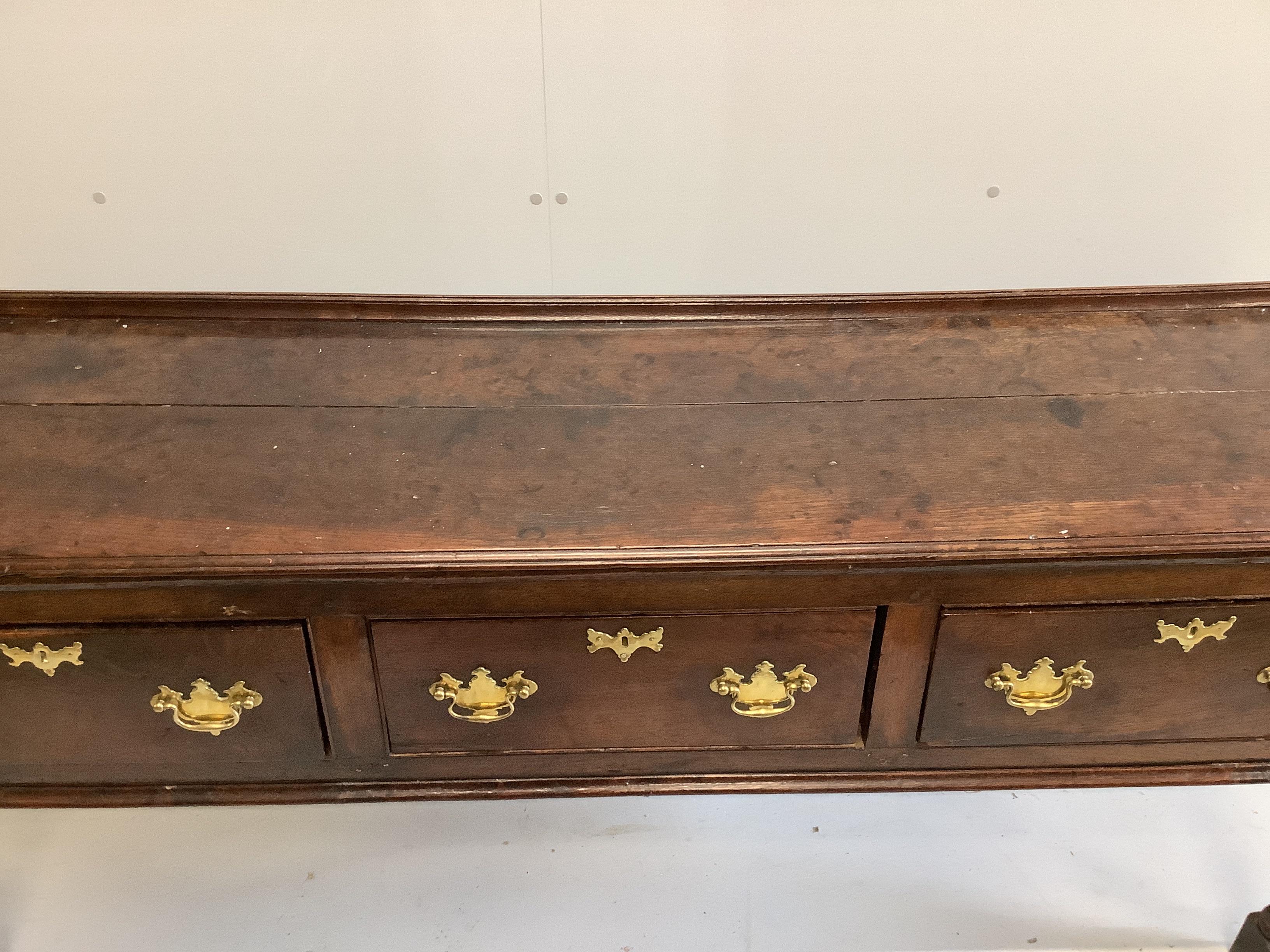 An 18th century oak low dresser, fitted with three drawers, raised on turned legs, length 184cm, depth 48cm, height 80cm